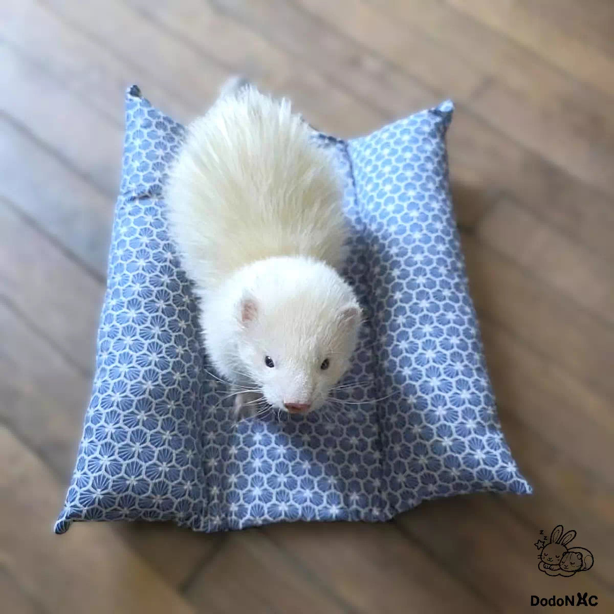 furet blanc mignon couché confortablement sur son snugabun rafraîchissant, snuggle bed, accessoire lapin, coussin absorbant fait main et personnalisé dodoNAC