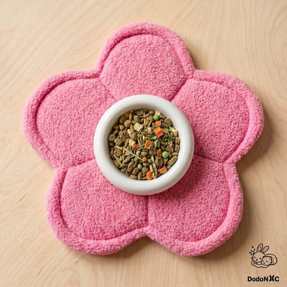 Tapis absorbant et tapis de gamelle en forme de fleur rose pour cochon d'Inde, avec une écuelle remplie au centre.