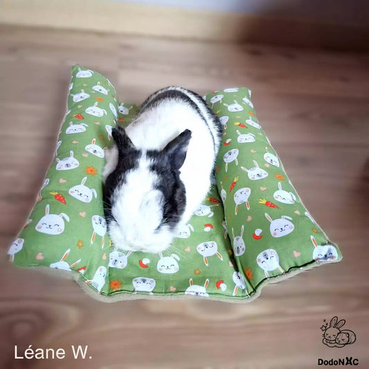 lapin mignon couché confortablement sur son snugabun, snuggle bed, accessoire lapin, coussin absorbant fait main dodoNAC