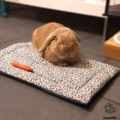 lapin couché sur un tapis moelleux douillé et confortable dodoNAC personnalisé avec un tissu motif fleurs et tissu polaire bleu